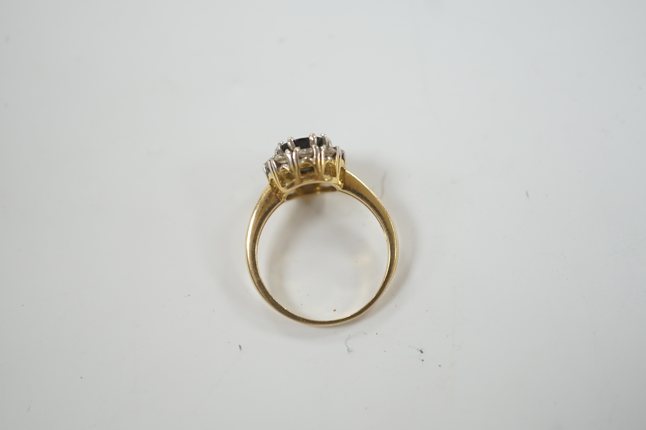 A modern 18ct gold, sapphire and diamond set oval cluster ring, size L, gross weight 3.8 grams.